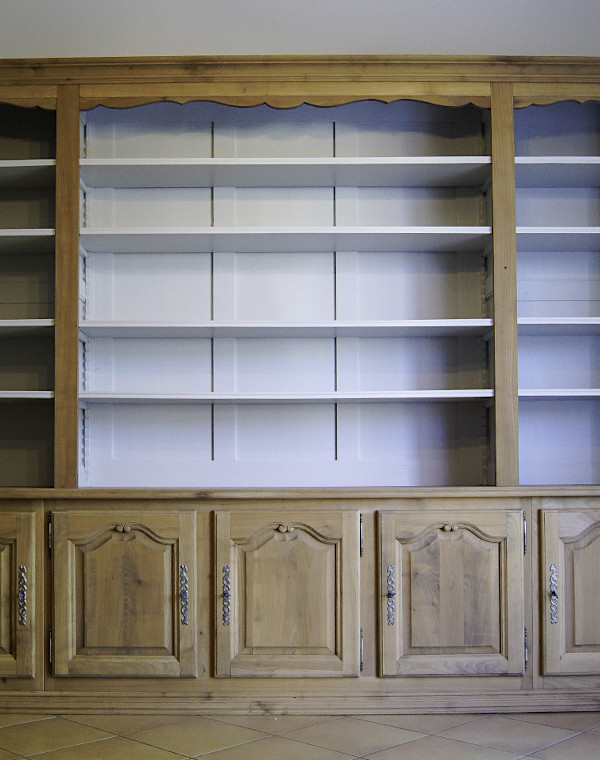 Bibliothèque repensée en bois naturel, intérieur gris clair. Finition d'ensemble vernis satin.